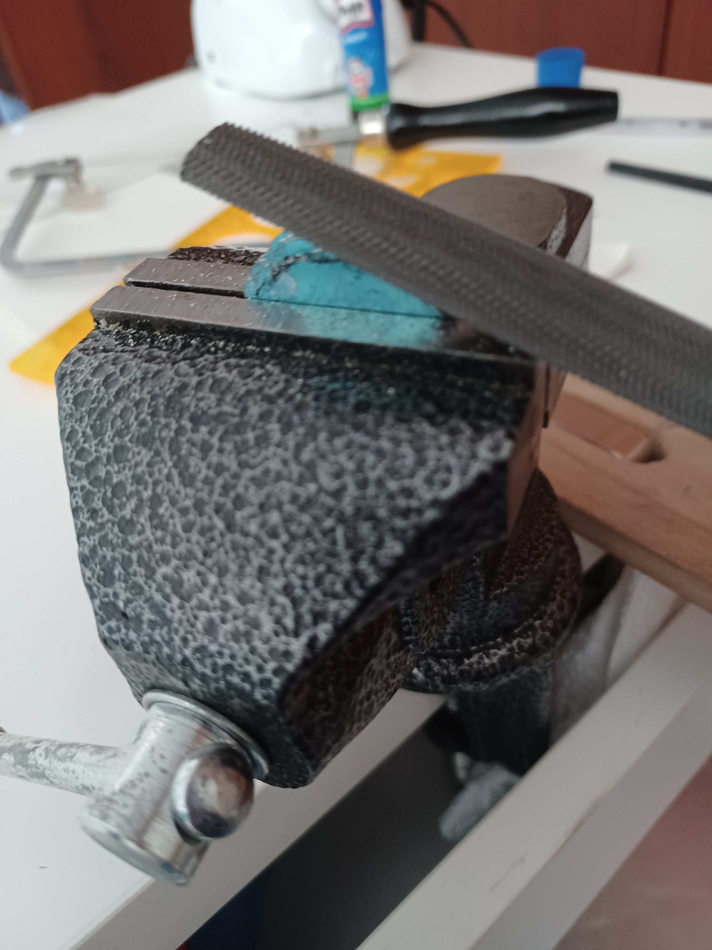 Close-up of a bench vice holding metal being filed